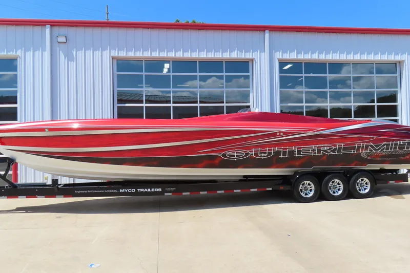 The Image of 2004 Outerlimits 42 Legacy speedboat on trailer, vibrant red and white design. - 0