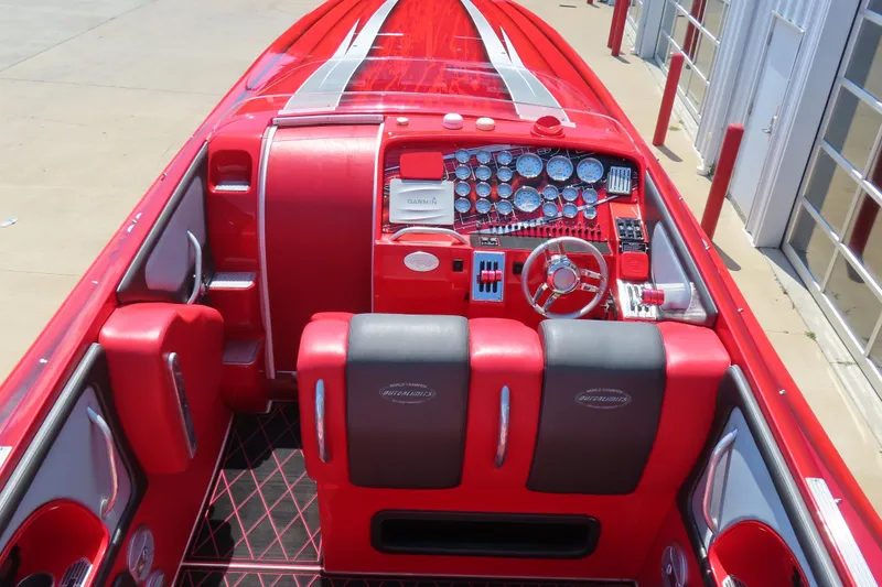Slide: The Image of 2004 Outerlimits 42 Legacy boat interior with red and black seating, detailed dashboard, and steering wheel. - 17