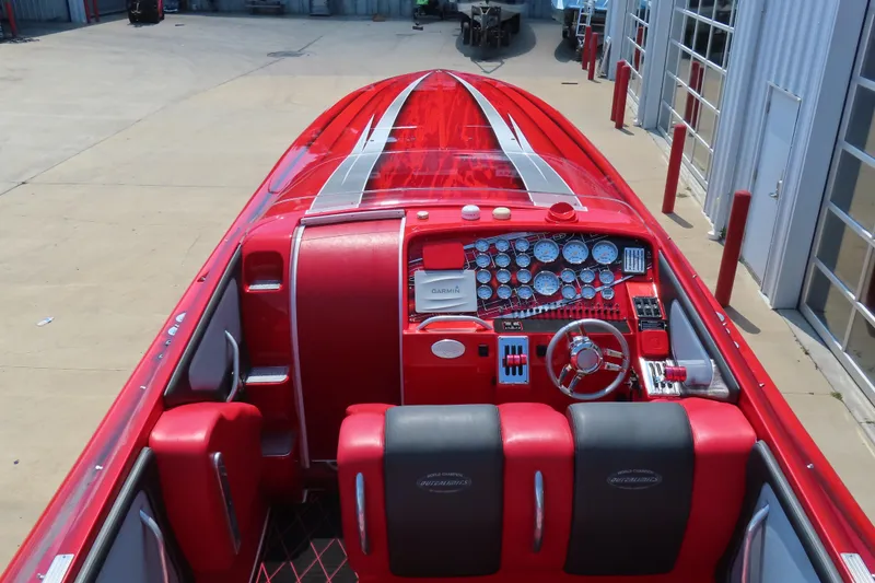 Slide: The Image of 2004 Outerlimits 42 Legacy speedboat cockpit with red and black interior, advanced dashboard controls. - 18