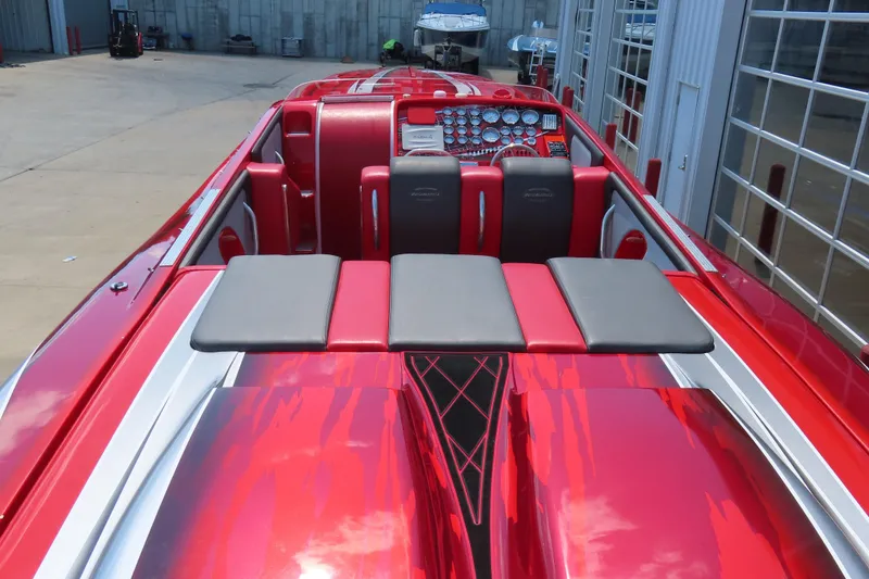 Slide: The Image of 2004 Outerlimits 42 Legacy speedboat with vibrant red and gray interior, docked at a marina. - 19