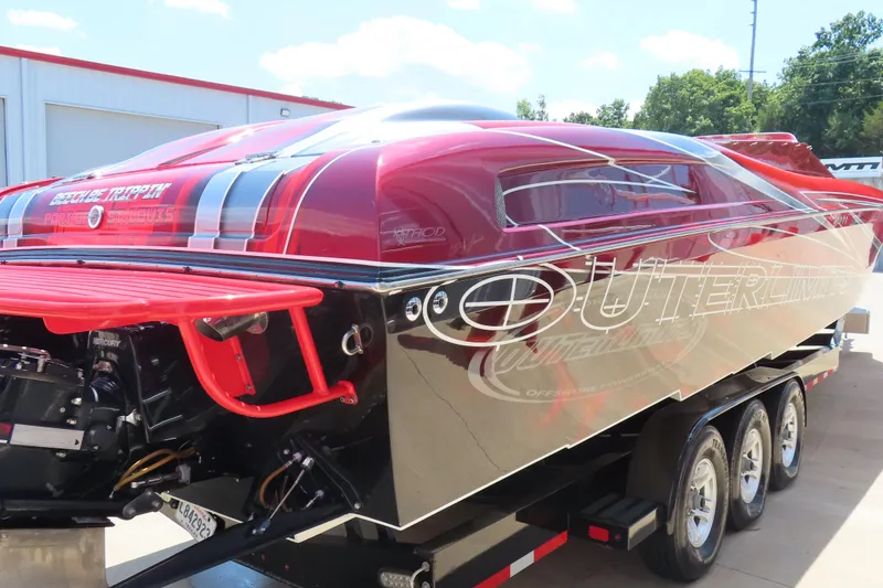 Slide: The Image of 2004 Outerlimits 42 Legacy speedboat with red and black design on a trailer. - 22