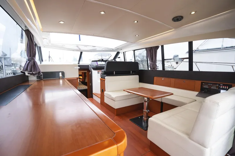 Slide: The Image of Interior of 2014 Jeanneau NC 14 yacht with modern seating and wooden finishes. - 13
