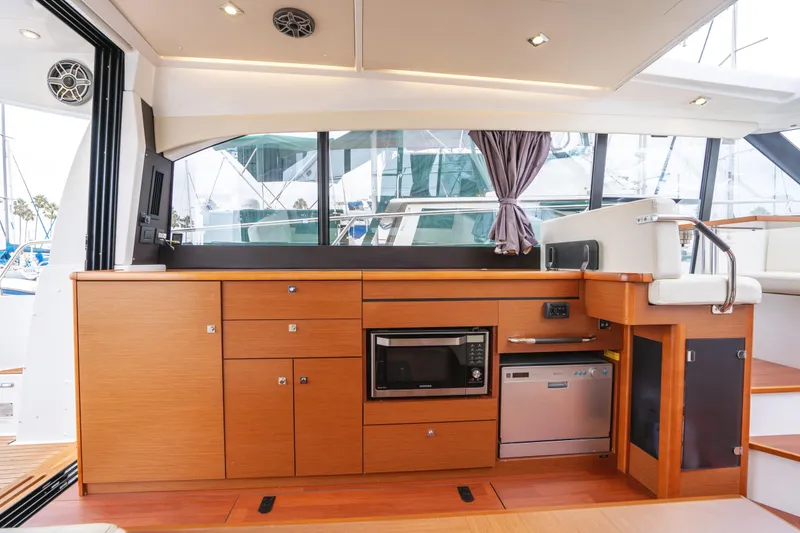Slide: The Image of Interior of 2014 Jeanneau NC 14 yacht with modern kitchen and wooden cabinetry. - 14