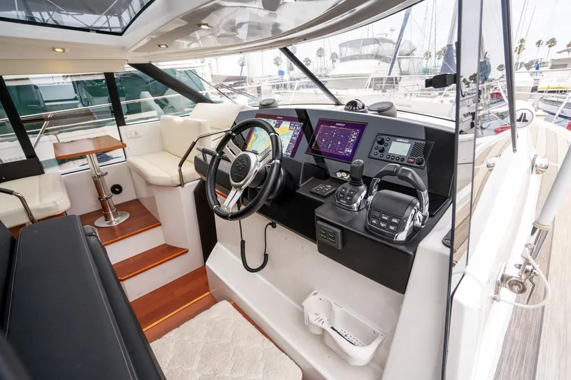 Slide: The Image of 2014 Jeanneau NC 14 yacht cockpit with modern navigation controls and luxurious seating. - 25