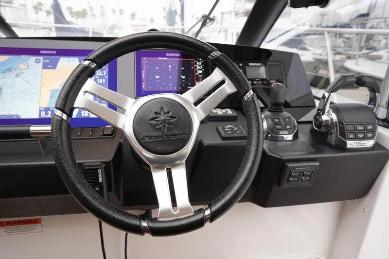 Slide: The Image of Steering wheel and controls of 2014 Jeanneau NC 14 boat with navigation displays. - 27