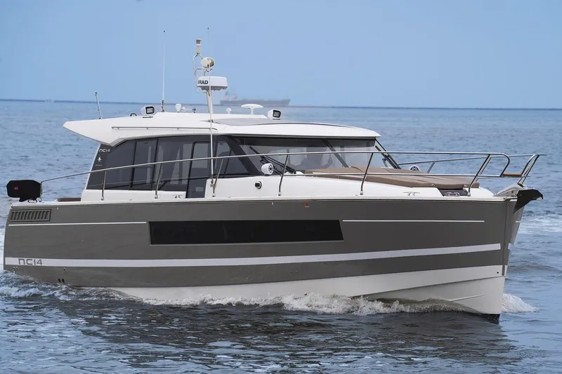 Slide: The Image of 2014 Jeanneau NC 14 motor yacht cruising on open water. - 5