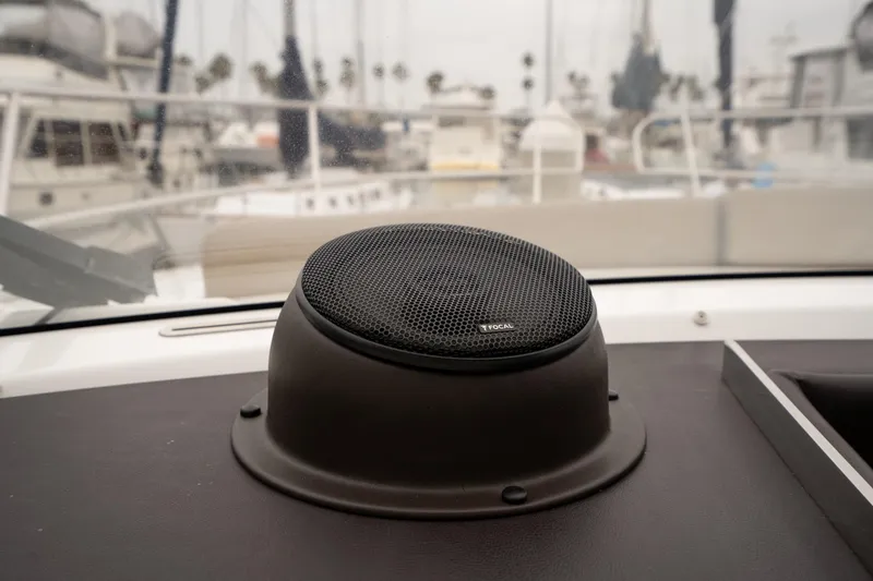 Slide: The Image of Speaker on Jeanneau NC 14 yacht dashboard, 2014 model, with marina background. - 51
