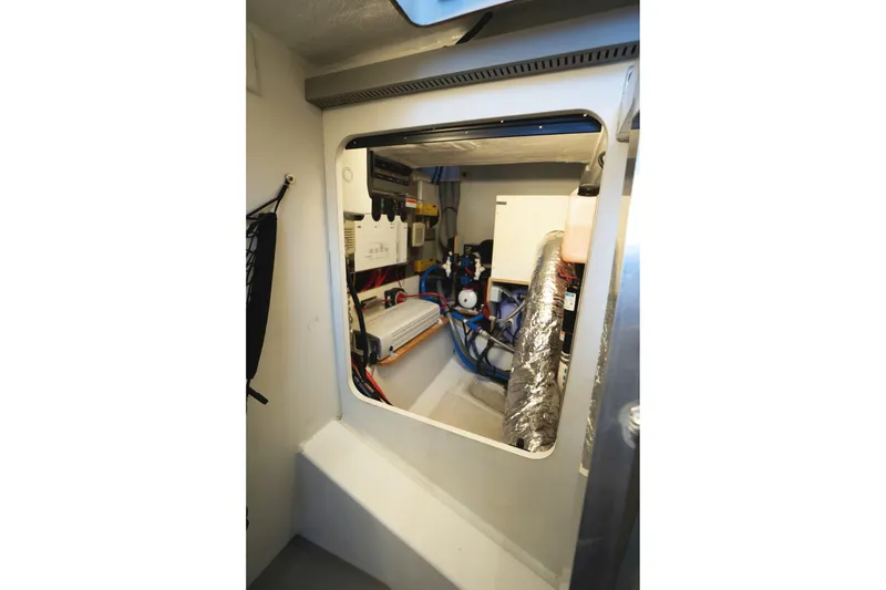 Slide: The Image of Engine room of 2014 Jeanneau NC 14 boat, showcasing mechanical components and wiring. - 55