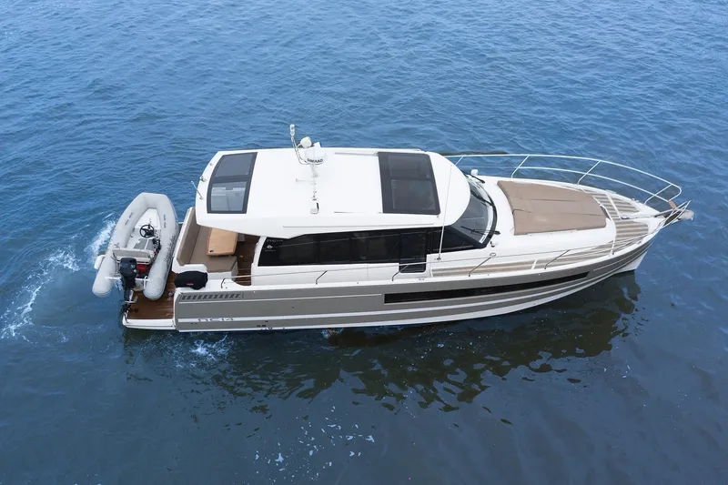 Slide: The Image of 2014 Jeanneau NC 14 yacht cruising on open water, aerial view. - 6
