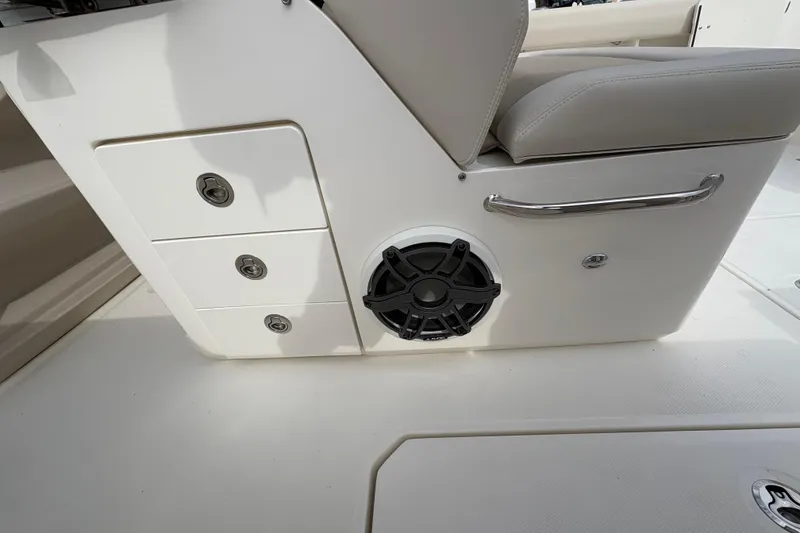 Slide: The Image of 2026 Boston Whaler 330 Outrage interior with storage drawers and speaker. - 8