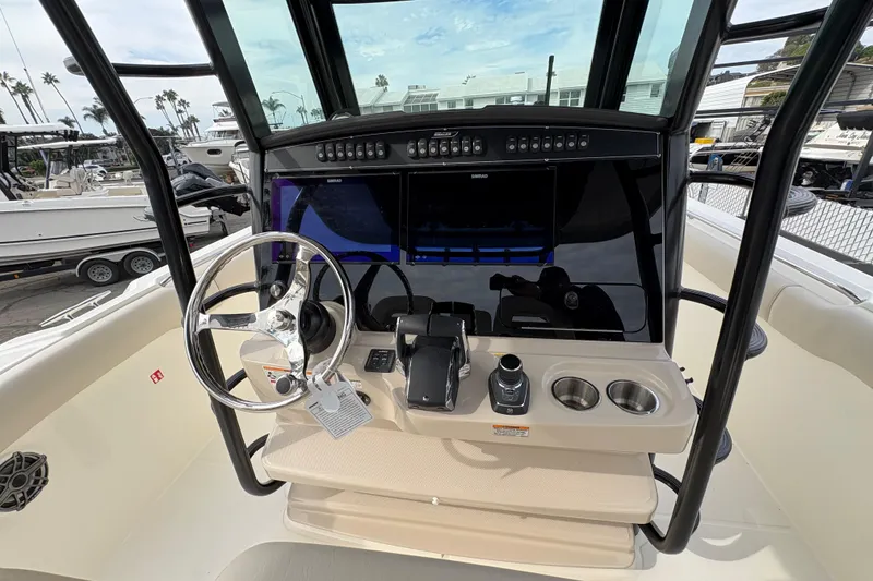 Slide: The Image of 2026 Boston Whaler 330 Outrage helm with steering wheel and control panel. - 9