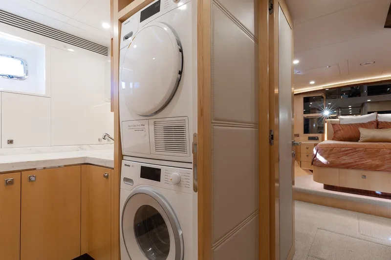 Slide: The Image of Laundry area and bedroom in a 2021 Horizon yacht, featuring modern appliances and luxurious design. - 18