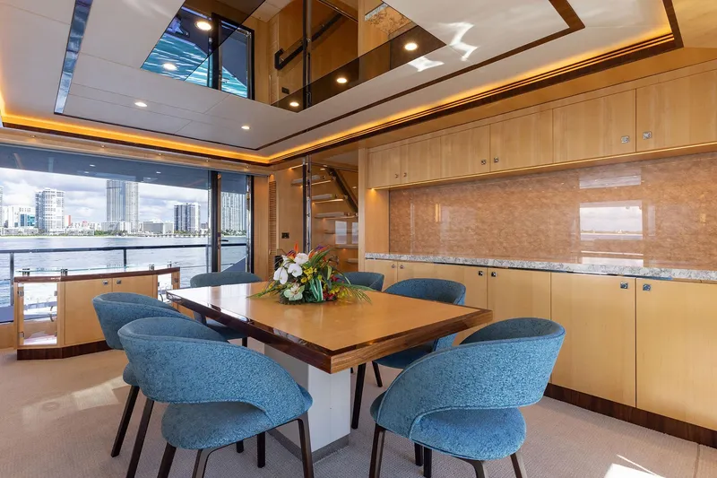 Slide: The Image of Luxurious yacht interior with modern dining area, blue chairs, and cityscape view, Horizon 2021 model. - 6