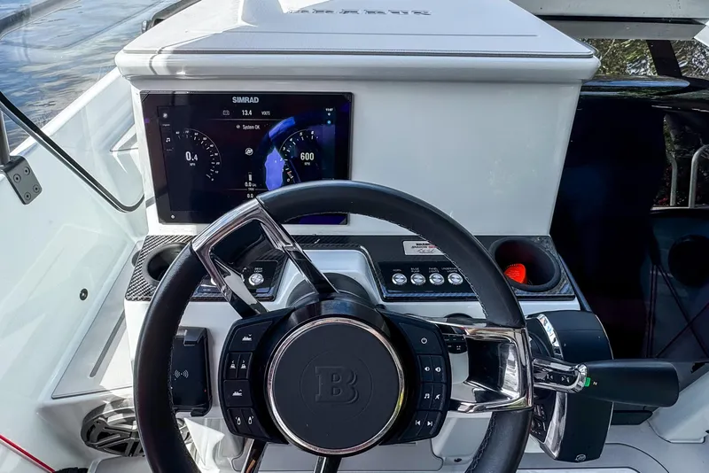 Slide: The Image of Steering wheel and dashboard of 2023 BRABUS Shadow 300 XT boat, featuring modern controls. - 12