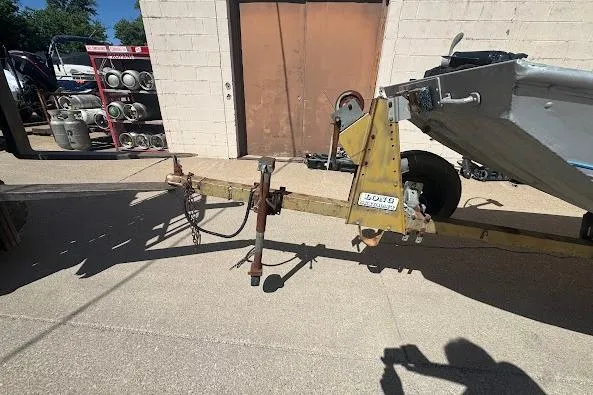 Slide: The Image of 1973 Monark 14 Jon boat trailer parked outside a building. - 10