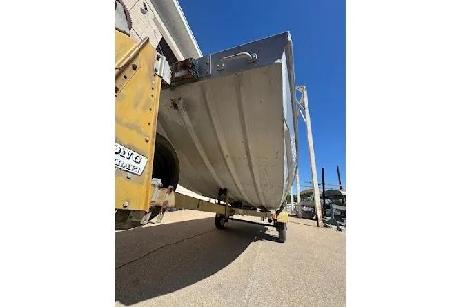 Slide: The Image of 1973 Monark 14 Jon boat on trailer, viewed from below, outdoors. - 11