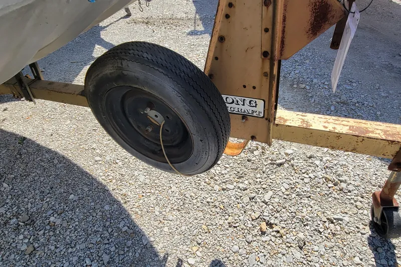 Slide: The Image of 1973 Monark 14 Jon boat trailer wheel on gravel surface. - 3