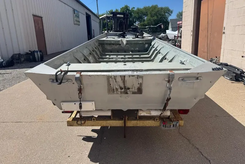 Slide: The Image of 1973 Monark 14 Jon boat on trailer, parked outside industrial building. - 7