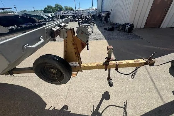 Slide: The Image of 1973 Monark 14 Jon boat trailer hitch and wheel on concrete surface. - 9