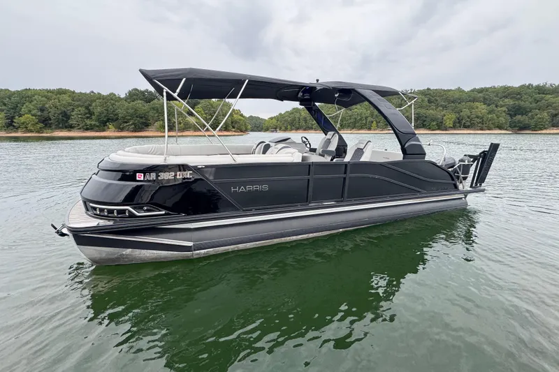 The Image of 2023 Harris Grand Mariner 250 pontoon boat on a serene lake. - 0