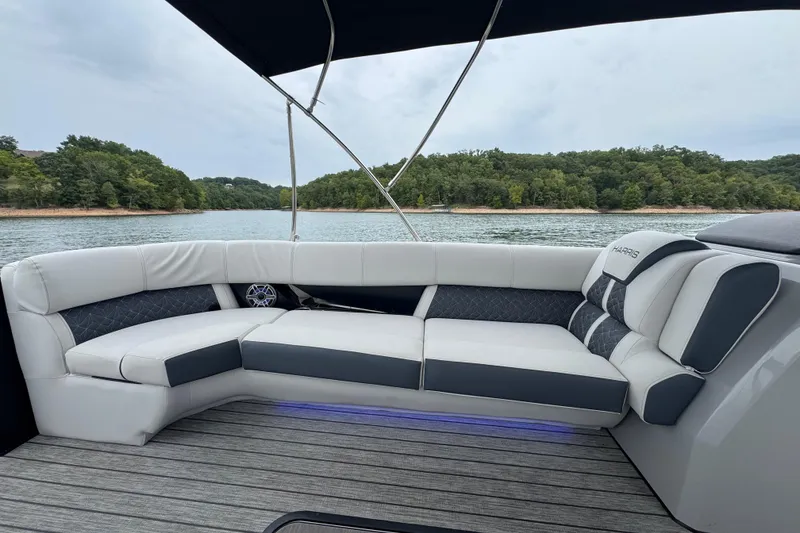 Slide: The Image of 2023 Harris Grand Mariner 250 boat interior with luxurious seating on a serene lake. - 10