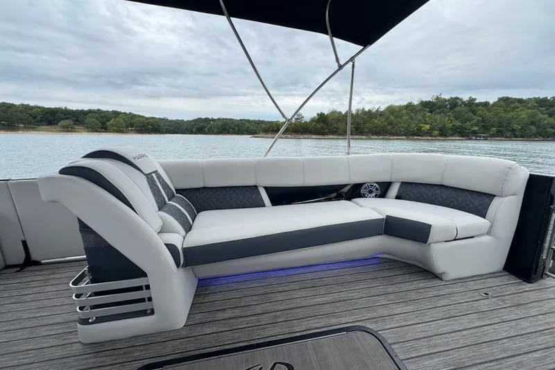Slide: The Image of 2023 Harris Grand Mariner 250 boat interior with luxurious seating on a serene lake. - 11