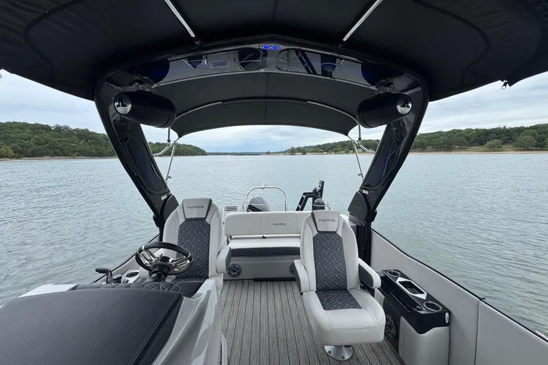Slide: The Image of 2023 Harris Grand Mariner 250 boat interior with luxurious seating on a serene lake. - 12