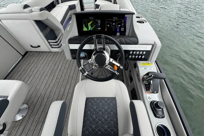 Slide: The Image of 2023 Harris Grand Mariner 250 helm with modern controls and luxurious seating on water. - 15