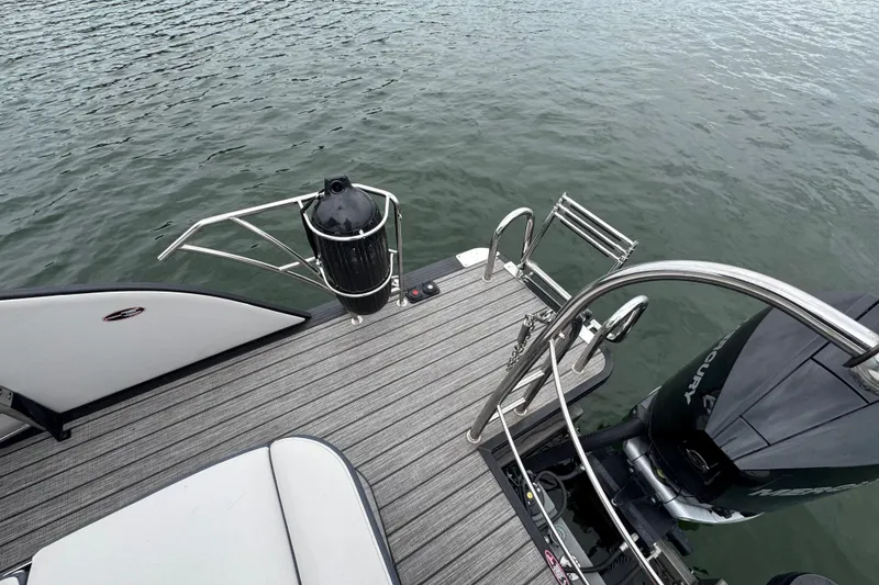 Slide: The Image of 2023 Harris Grand Mariner 250 boat deck with ladder and Mercury engine on water. - 20