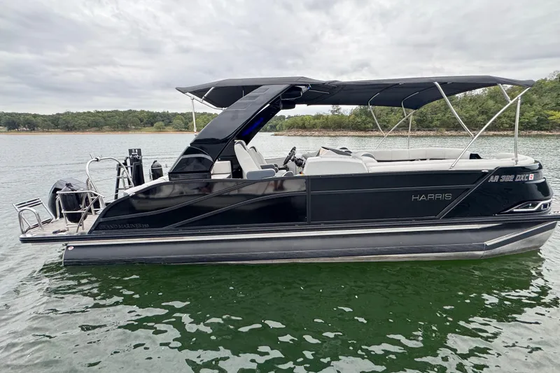 Slide: The Image of 2023 Harris Grand Mariner 250 pontoon boat on a serene lake. - 3