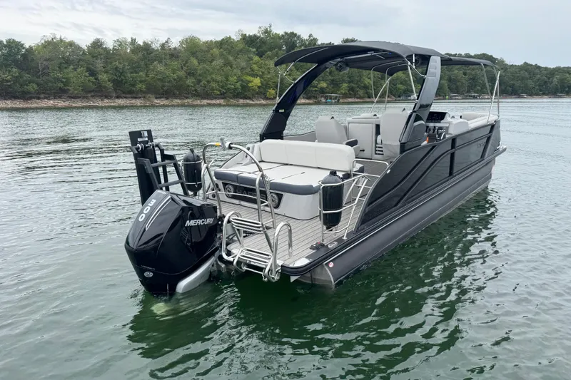 Slide: The Image of 2023 Harris Grand Mariner 250 pontoon boat on a calm lake. - 6