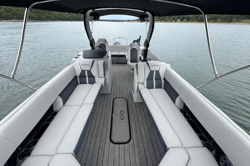 Slide: The Image of 2023 Harris Grand Mariner 250 pontoon boat interior with luxurious seating on a calm lake. - 8