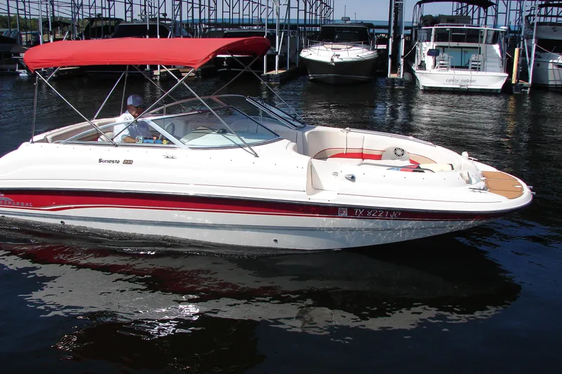 Slide: The Image of 1999 Chaparral Sunesta 233 boat with red canopy docked in marina. - 0