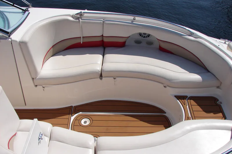 Slide: The Image of 1999 Chaparral Sunesta 233 boat interior with white seating and wooden flooring. - 10