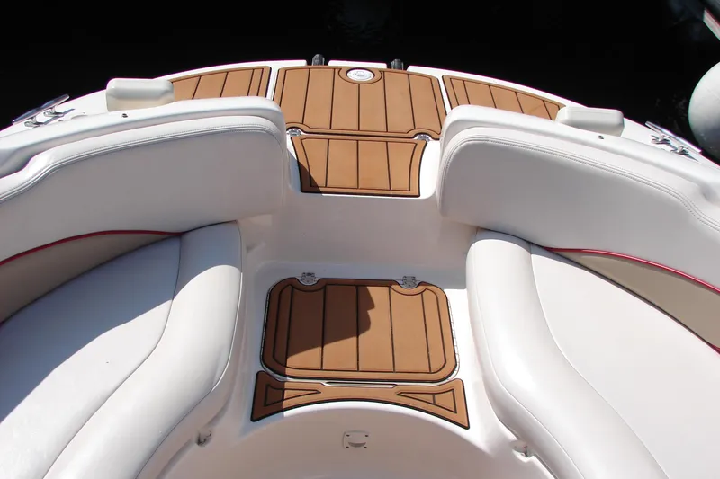 Slide: The Image of 1999 Chaparral Sunesta 233 boat interior with white seating and brown deck. - 11