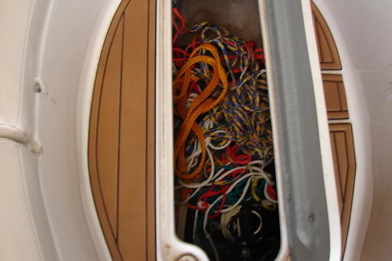 Slide: The Image of Storage compartment with colorful ropes on a 1999 CHAPPARRAL 233 Sunesta boat. - 14