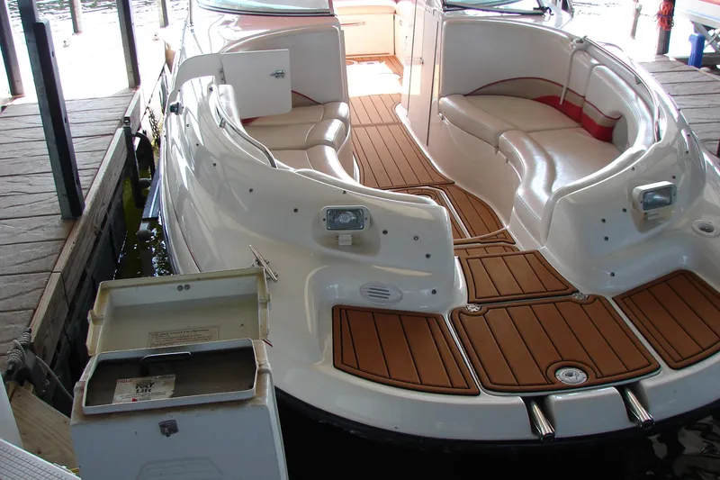 Slide: The Image of 1999 CHAPPARRAL 233 Sunesta boat with spacious seating and wooden deck in a dock. - 16