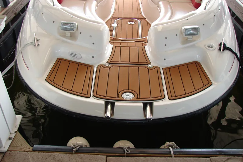 Slide: The Image of 1999 CHAPPARRAL 233 Sunesta boat with teak-style deck, docked in water. - 18