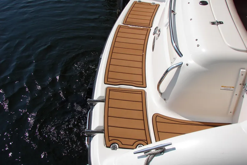 Slide: The Image of 1999 CHAPPARRAL 233 Sunesta boat deck with teak-style flooring on water. - 21