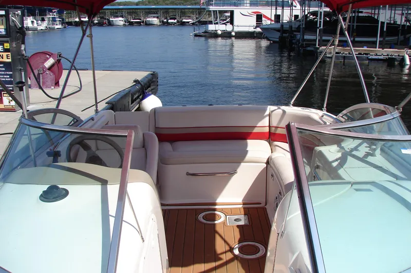 Slide: The Image of 1999 Chaparral Sunesta 233 boat interior with seating, docked at marina. - 25