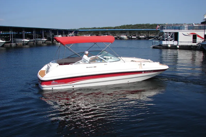 Slide: The Image of 1999 Chaparral Sunesta 233 boat with red canopy on a calm lake. - 4