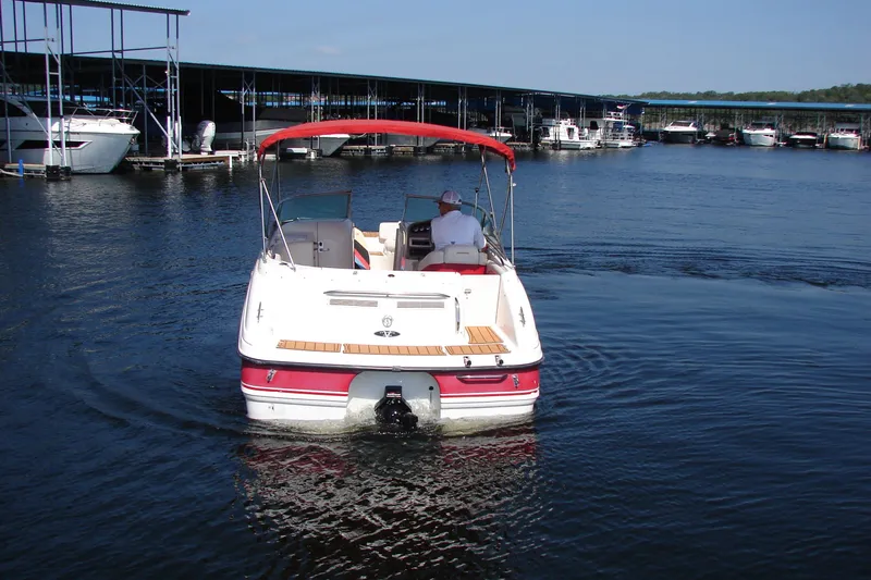 Slide: The Image of 1999 Chaparral Sunesta 233 boat cruising on a lake near a marina. - 5