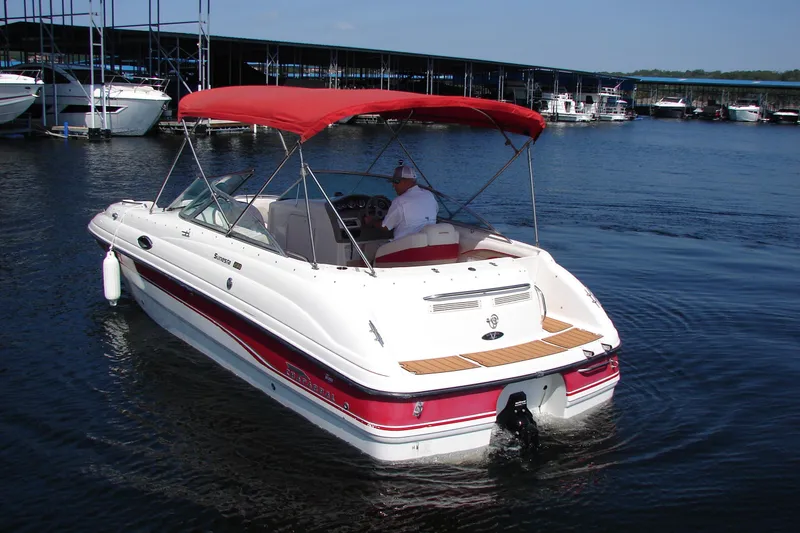 Slide: The Image of 1999 Chaparral Sunesta 233 boat with red canopy on a calm lake. - 6