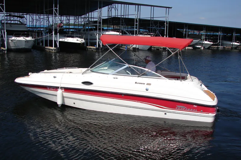 Slide: The Image of 1999 Chaparral Sunesta 233 boat with red canopy docked at marina. - 8