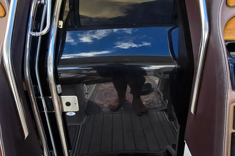 Slide: The Image of Reflection on a 2011 Cobalt 323 boat door with chrome handles and sky view. - 13