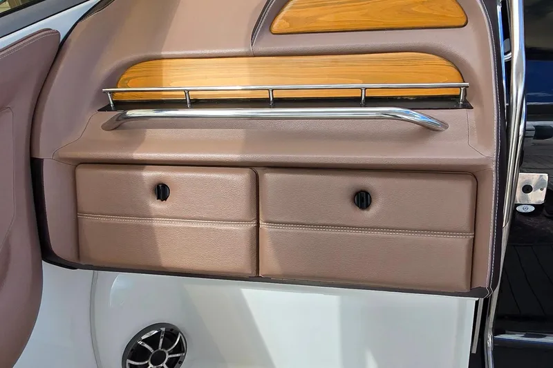 Slide: The Image of 2011 Cobalt 323 interior with tan leather storage compartments and wood accents. - 19