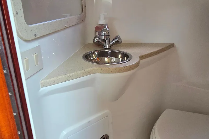 Slide: The Image of Compact bathroom sink in 2011 Cobalt 323 boat, featuring a stainless steel basin and faucet. - 35