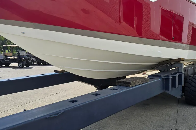 Slide: The Image of Red and white 2011 Cobalt 323 boat on a trailer, parked outdoors. - 5