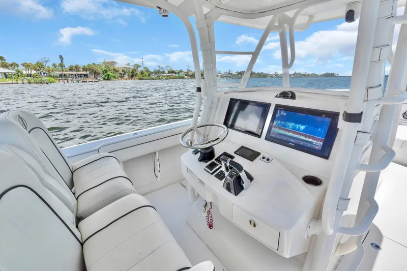 Slide: The Image of 2017 Jupiter 34 FS boat cockpit with modern navigation screens and comfortable seating. - 12