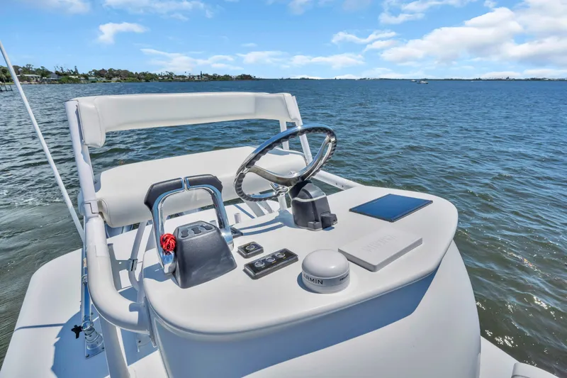 Slide: The Image of 2017 Jupiter 34 FS boat helm with steering wheel and controls on open water. - 14